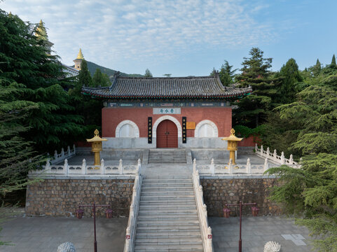 Pujiji Temple entrance at Mount Putuo with red walls stone steps and traditional architecture under clear sky