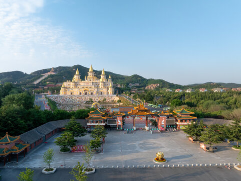 Lingshan Grand Buddha Temple's golden Vihara complex with traditional Chinese architecture and mountainous backdrop