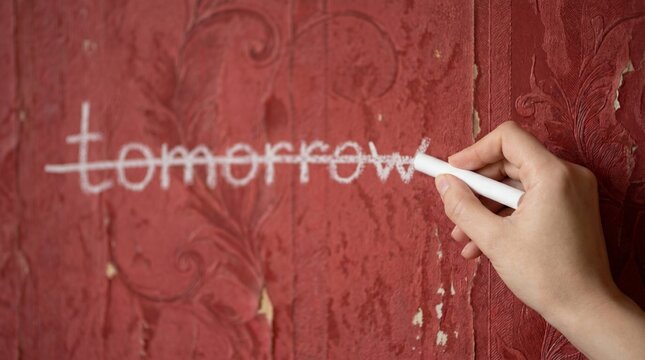A hand crosses out "tomorrow" in chalk on aged red damask wallpaper. It conveys a poignant sense of finality and the erasure of future potential in a faded, elegant setting.