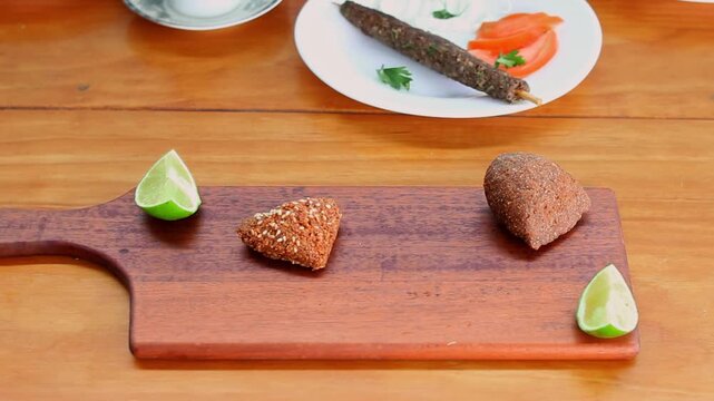 Heart shaped kibbeh with sesame seeds held in front of Syrian flag, traditional Lebanese and Syrian Middle Eastern cuisine concept featuring handmade fried bulgur croquette and cultural gastronomy