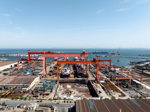Large shipyard port operation scene panoramic view with cranes and vessel construction