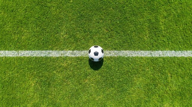 Soccer ball on the green grass of a football field top view of a ball on the white line of a stadium pitch concept of sports, competition, and healthy lifestyle
