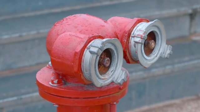 A close-up of a red fire hydrant standing on the sidewalk in Da Lat City, Vietnam