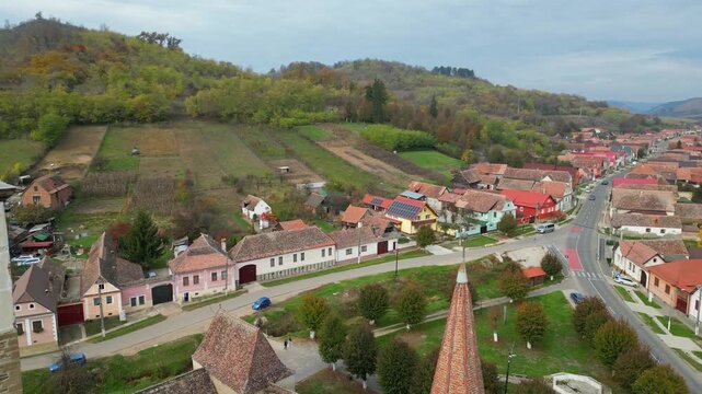 High angle view of the historic Mosna fortified church in Sibiu county. A beautiful 14th-century Gothic Saxon monument surrounded by defensive walls and towers in rural Transylvania, Romania.