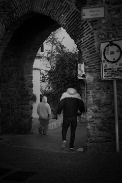 black and white, street photography, archway, old town, historic, people, monochrome, alley, architecture, urban, stone arch, documentary, candid, travel, city life, moody, vintage, narrow street, cul