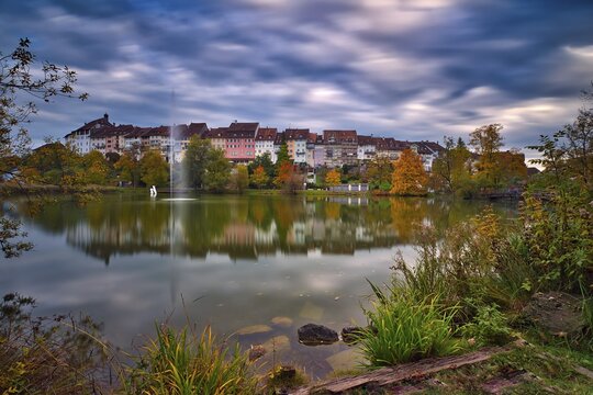Reflection of the old town of Wil in the pond of the municipal park, thunderclouds at the blue hour, Canton St. Gallen, Switzerland