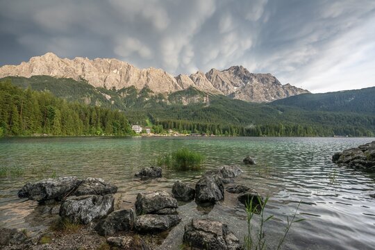 Rocks on the shore, Lake Eibsee lake in front of Zugspitze massif with Zugspitze, dramatic Mammaten clouds, Wetterstein range, near Grainau, Upper Bavaria, Bavaria, Germany