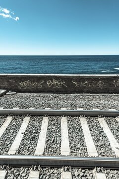 Railroad tracks in front wall with graffiti in front of the sea, Cinque Terre, La Spezia, Cinque Terre, Liguria, Italy