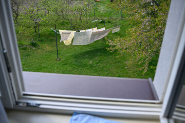 Fototapeta premium View from a window of bed linen drying outside on a clothesline.