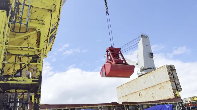 discharging wheat from ship to port hopper by the ship crane and cargo grab.