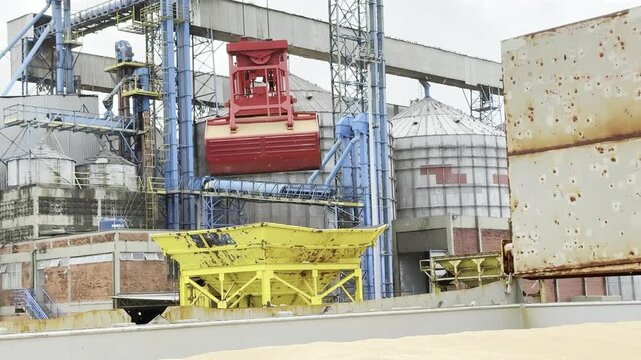 discharging wheat from ship crane and grab full cycle. grab closing and filling with grain. reduce leaking. bring cargo to hopper on berth. open grab.