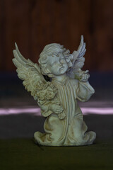 Fototapeta premium Ceramic cherub angel figurine on the floor inside a church interior.