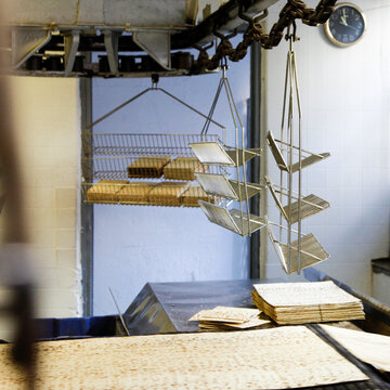 Industrial matzo factory machinery with hanging trays and conveyor belts