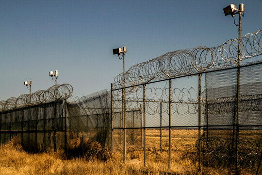 Barbed wire security fence in a dry rural landscape