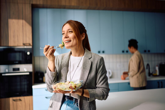 Happy businesswoman having lunch break while working in office.