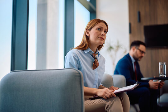 Worried businesswoman waiting for job interview in office lobby.