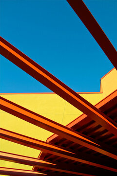 Bold orange beams and yellow wall against blue sky
