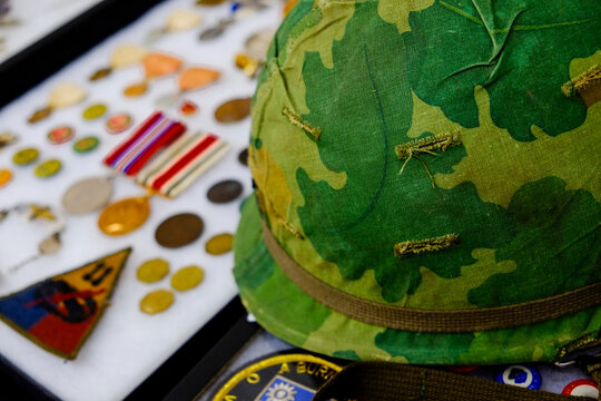 Camouflage helmet with vintage military buttons and medals