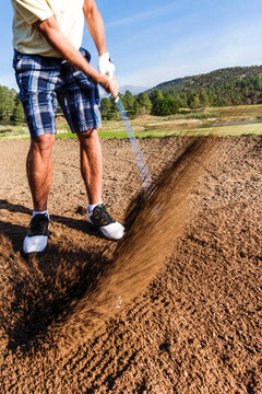 Golfer hitting a shot from a sand bunker