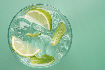 Fresh mojito cocktail top view with transparent ice lime and mint on pastel green background © hannamartysheva