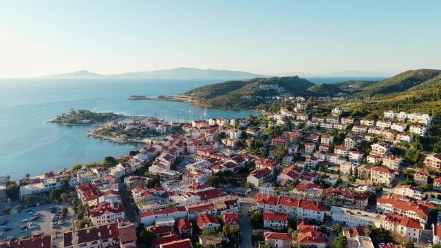 Aerial view of coastal town sweeping along mediterranean coastline with red rooftop houses and hillside marina of Datcha Turkey.
