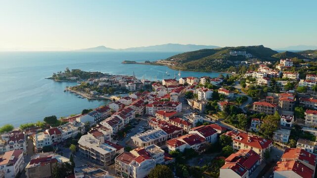 Aerial orbit slow motion of coastal town and marina of Datcha Turkey along mediterranean bay with panoramic descending pan.
