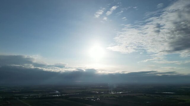 Aerial 4K sun flare and horizon, drone shot of sunrise sky atmosphere, cinematic hazy weather background, 4K UHD sun glow, flying towards the sun, peaceful morning landscape, bright atmospheric aerial
