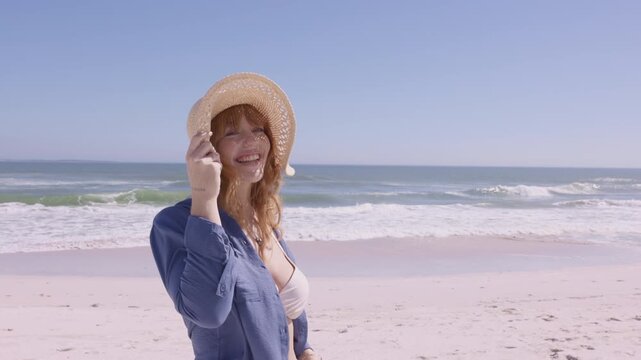 Joyful young woman with straw hat at summer beach