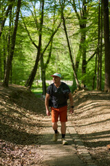 Obraz premium Man hiking on sunken forest trail
