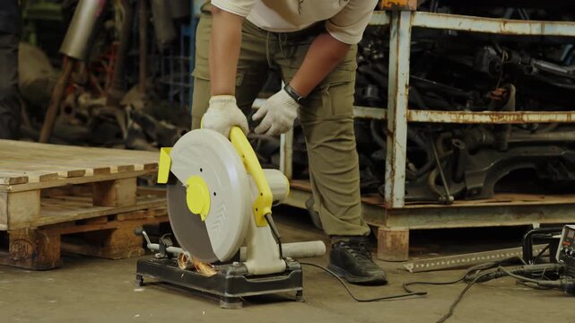 Industrial used car concept of 4k Resolution. Worker using steel cutting tool in factory, Chop Saw, Cutting a metallic rod by a circular saw machine.