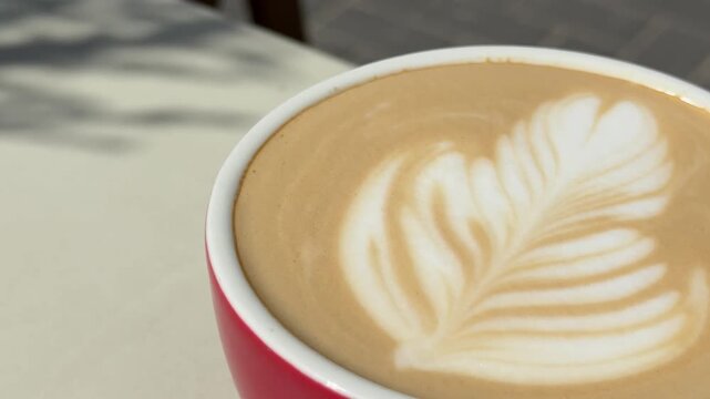 red cup Latte art in a cozy cafe Latte foam art relaxed morning vibe