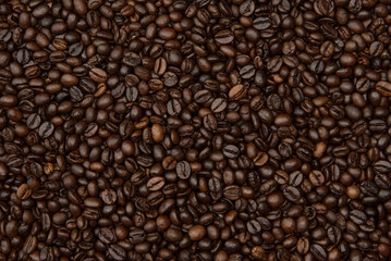 Obraz premium Beautiful dark background with fresh roasted and quality coffee beans steaming with rich aroma