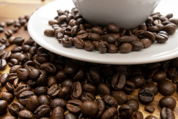 Fototapeta premium Premium dark roast arabica coffee beans with cozy cup of warm steaming coffee with late art