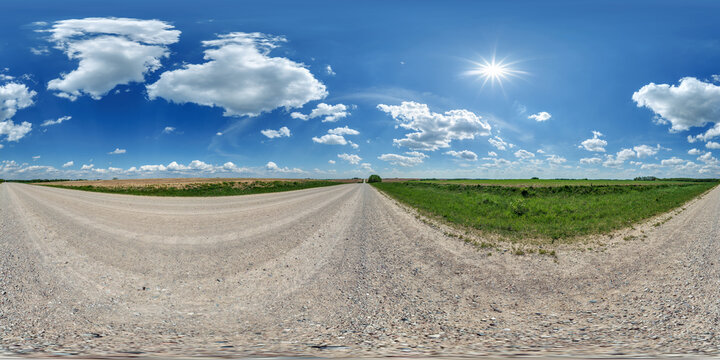 hdri 360 panorama view on gravel country roads among fields with beautiful clouds in sky in equirectangular full seamless spherical projection, ready for VR AR or skydome replacement