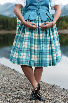 Highland dancer in blue Aboyne dress with proper hand position by mountain lake