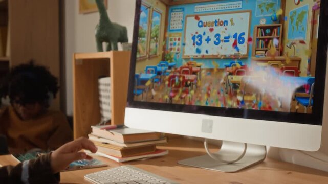 Over-shoulder close-up of young kid solving math sums on computer, using colorful interactive app on edtech website, featuring classroom with confetti burst for correct answers, early age education