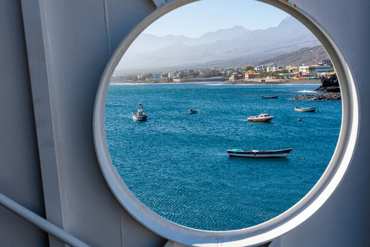 Beautiful view of Porto Novo with small fishing boats seen through the round window of a ferry boat that makes the crossing between S&atilde;o Vicente Island and Santo Ant&atilde;o, Cape Verde.