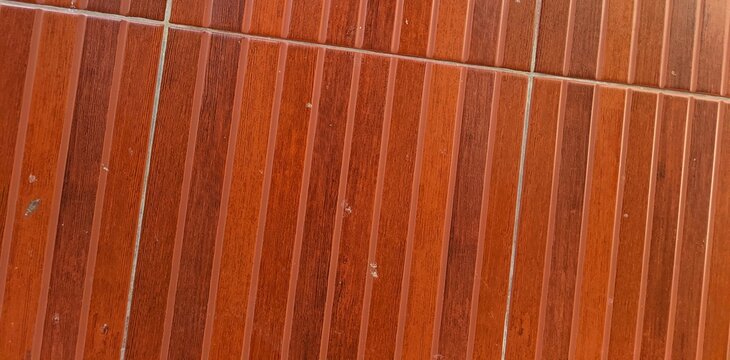 Wooden floor tiles arranged in parallel rows. Warm tones enhance the natural texture. Each tile shows unique grain patterns. Perfect for interior design or decor projects. Simplistic style adds calm