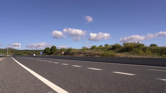 Carretera comarcal de la Comunidad de Madrid con varios coches circulando entre el paisaje rural y la vegetaci&oacute;n del entorno.