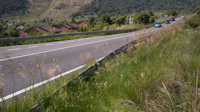 Detalle de una carretera comarcal de la Comunidad de Madrid con varios coches circulando entre el paisaje rural y la se&ntilde;alizaci&oacute;n vial.