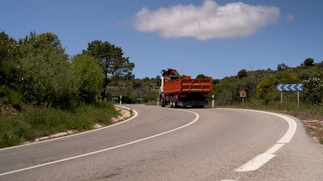 Cami&oacute;n circulando por una carretera comarcal con curvas. Madrid, Espa&ntilde;a, mayo de 2026.