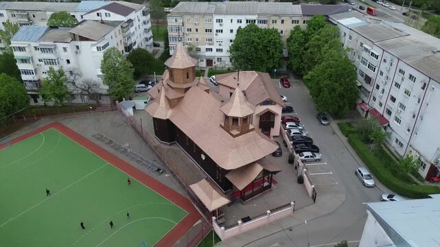 Cinematic aerial shot of an ancient traditional wooden church in Vaslui, Romania. Heritage landmark of Eastern Europe.