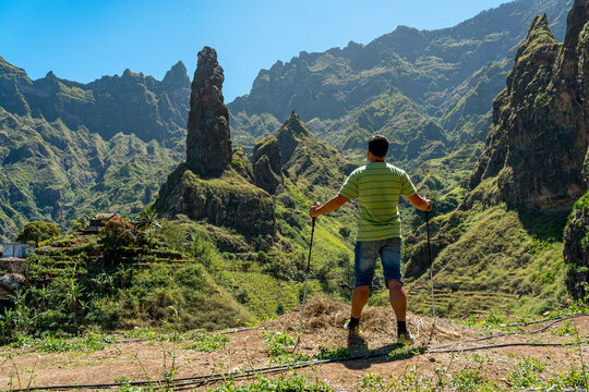 An unidentified white European man, with his back turned, leaning on walking sticks, contemplates the mountains of the Paul Valley in Santo Ant&atilde;o, Cape Verde.