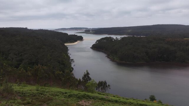 Furna do sapo viewpoint overlooking a winding river estuary surrounded by green forests under an overcast sky