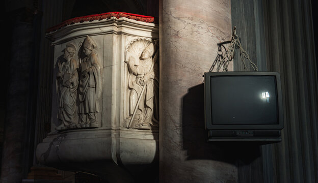 Old television hanging next to religious church pulpit
