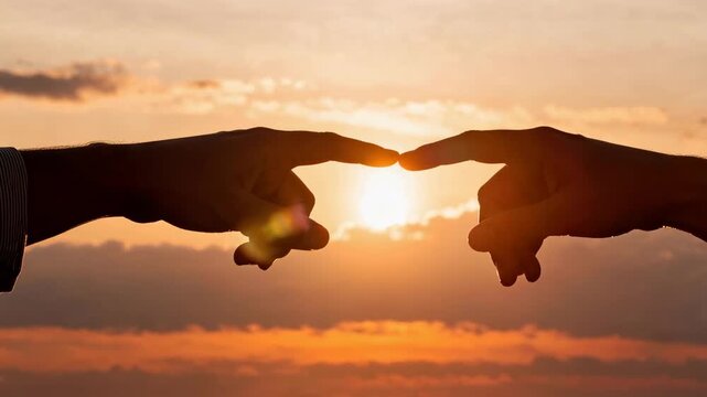 二人の手が夕焼け空で指先を静かにつなぐ瞬間