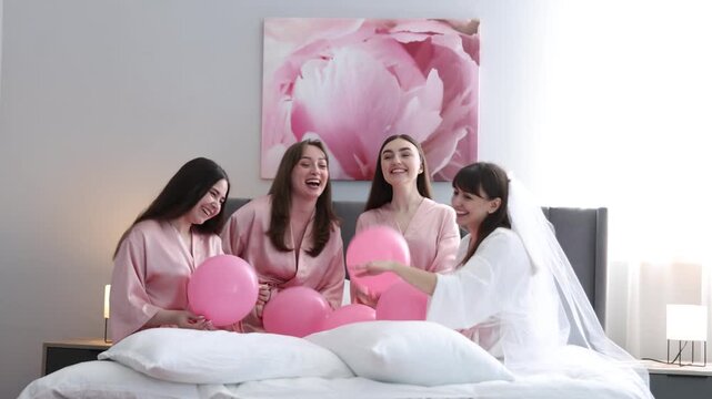 Bachelorette party. Group of women in bathrobes with balloons having fun indoors