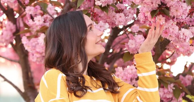 Beautiful woman near blossoming tree on spring day