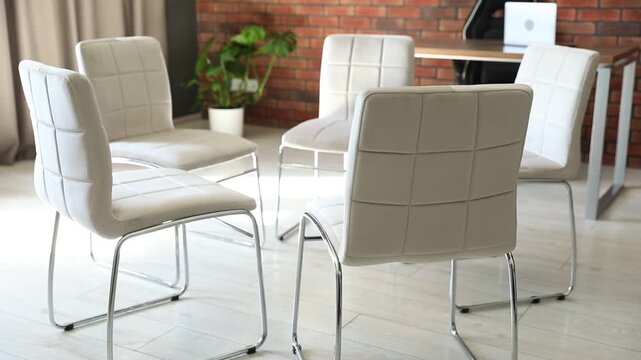 Stylish comfortable chairs in circle indoors. Camera moving down