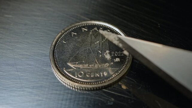 Educational concept of Fentanyl of two milligrams on the ten cents Canadian coin, lethal dose for people in most cases. Fentanyl potent synthetic opioid drug approved for use analgesic, pain relief.
